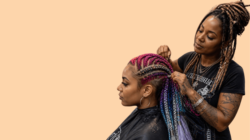 Stylist creating colourful braids